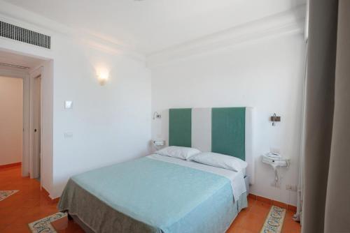 a bedroom with a bed with a green and white wall at Suite Tramonto in dependance in Conca dei Marini