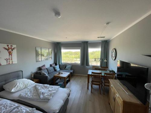a bedroom with a bed and a living room at Kaleu in Burgtiefe auf Fehmarn 