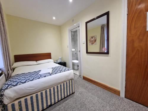 a hotel room with a bed and a mirror at Hotel 65 in London