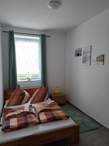 a bedroom with a bed with green curtains and a window at Janita in Meeschendorf
