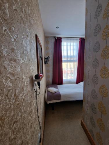 a small room with a bed and a window at Hotel 65 in London