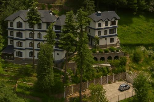 a large house with a car parked in front of it at Vilãsa Lall Ji Resort in Dalhousie