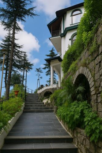 a stairway leading up to a building with plants at Vilãsa Lall Ji Resort in Dalhousie