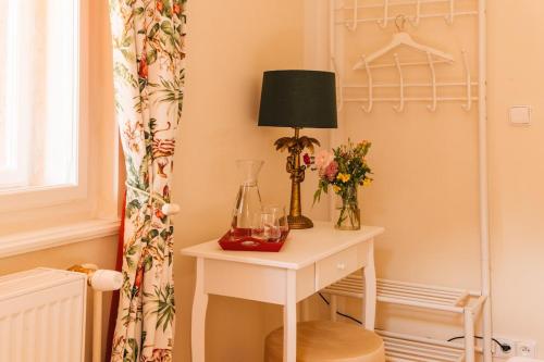 a room with a table with a lamp and flowers at Zámecká Stodola - Červený Hrádek u Sedlčan in Sedlčany