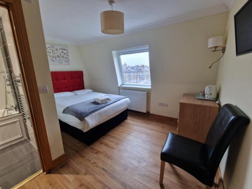a small bedroom with a bed and a chair at Hotel 65 in London