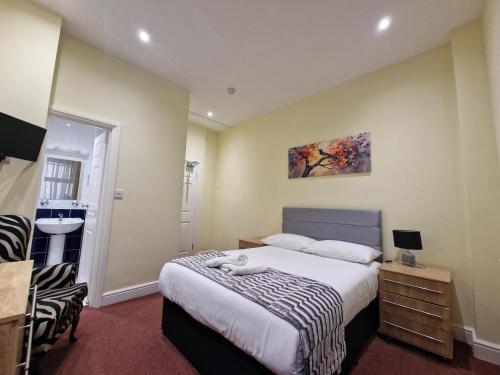 a small bedroom with a bed and a sink at Hotel 65 in London
