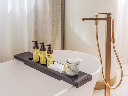 a bathroom with a shelf with bottles on a bath tub at ME Lisbon by Meliá in Lisbon