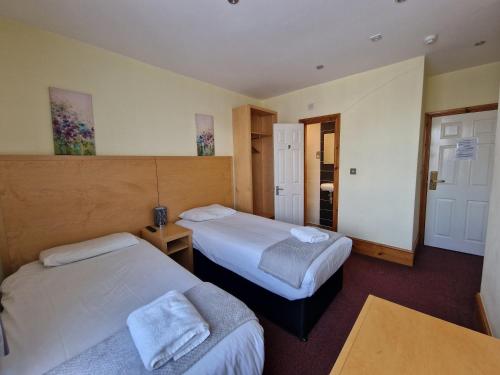 a hotel room with two beds and a table at Hotel 65 in London