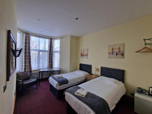 a hotel room with two beds and a window at Hotel 65 in London