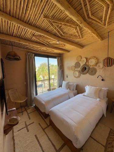 two beds in a room with a large window at Palm Surf & Spa Hotel Agadir in Agadir