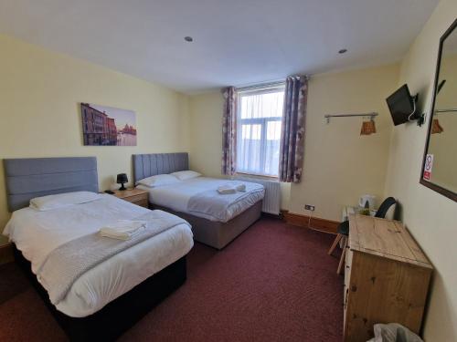 a hotel room with two beds and a window at Hotel 65 in London