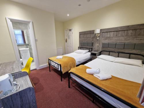 a hotel room with two beds and a sink at Hotel 65 in London