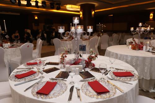 a table set with white tables with red napkins at CK Farabi Hotel in Ankara