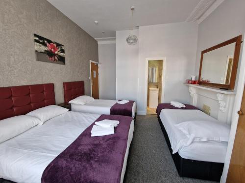 a hotel room with two beds and a fireplace at Hotel 65 in London
