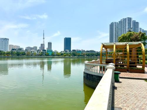a boat is docked next to a river with a city at Delux Stu Apt In Vinhomes, Close to JW Marriott, Keangnam and My Dinh in Hanoi