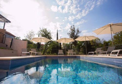 a large swimming pool with umbrellas and chairs at Apartments Villa Lukas in Cavtat