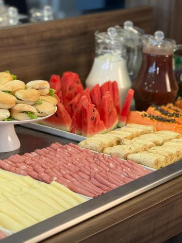 a buffet of different types of sandwiches and fruit at Dunamys Hotel Londrina in Londrina