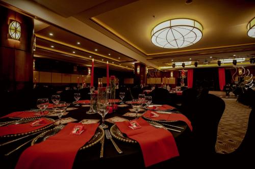 a dining room with tables with red napkins and wine glasses at CK Farabi Hotel in Ankara