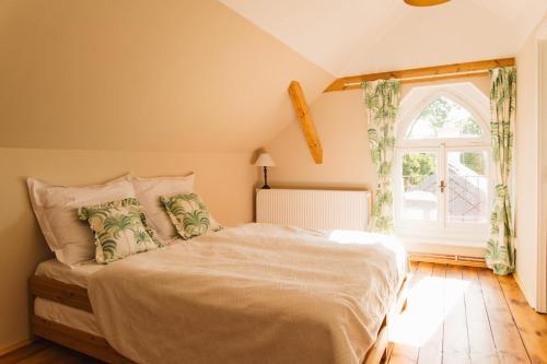 a bedroom with a large bed with a window at Zámecká Stodola - Červený Hrádek u Sedlčan in Sedlčany