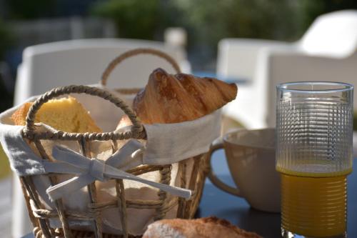 a basket of bread on a table with a glass of beer at Chambres d'hôtes PANCHIEN in Nouzilly