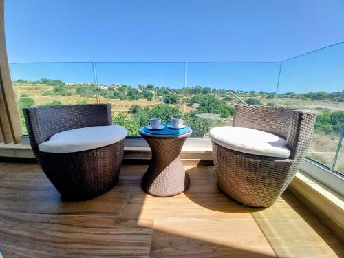 three wicker chairs sitting in front of a window at OpenView Apartment Marsaxlokk in Marsaxlokk