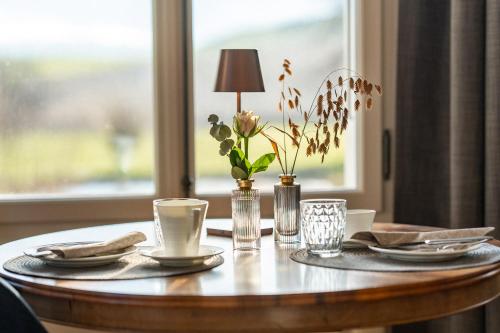 a table with plates and a lamp on top of it at Le Ruedli - Villa 1878 in Spiez