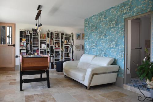 a living room with a white chair and a table at Chambres d'hôtes PANCHIEN in Nouzilly