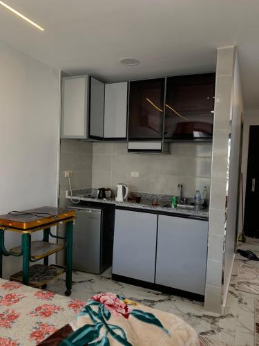 a kitchen with white cabinets and a table at Studio in Porto Said Compound in Port Said