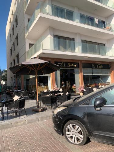 a car parked in front of a restaurant with tables and chairs at Studio in Porto Said Compound in Port Said