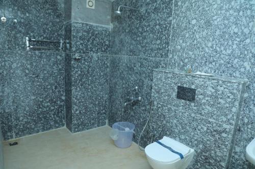 a bathroom with a shower and a toilet at Le Kumar Residency in Puducherry