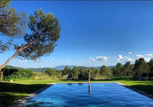 a swimming pool in a yard with a tree at La Garriga de Castelladral in Castelladral