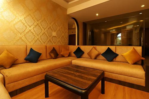 a couch with pillows and a coffee table in a room at Vilãsa Lall Ji Resort in Dalhousie