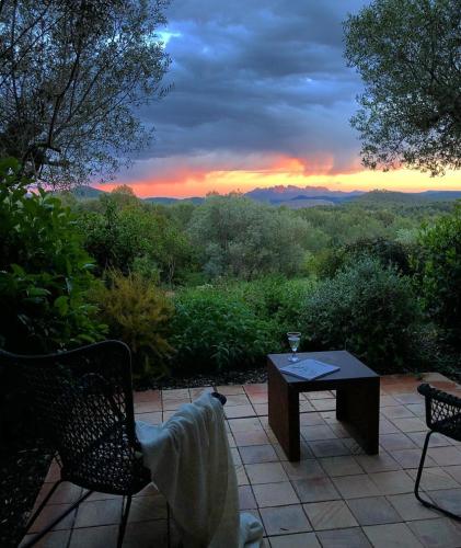 a patio with a table and chairs and a sunset at La Garriga de Castelladral in Castelladral