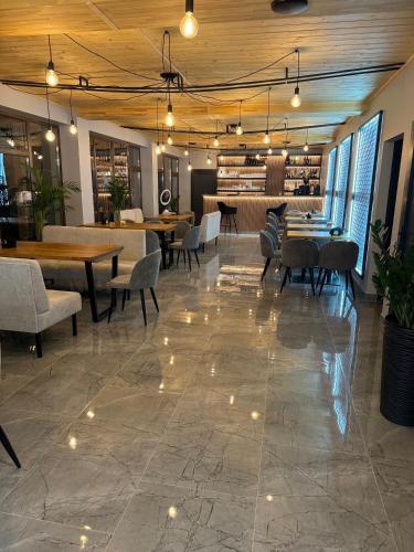 a dining room with tables and chairs and lights at Байлово SPA 
