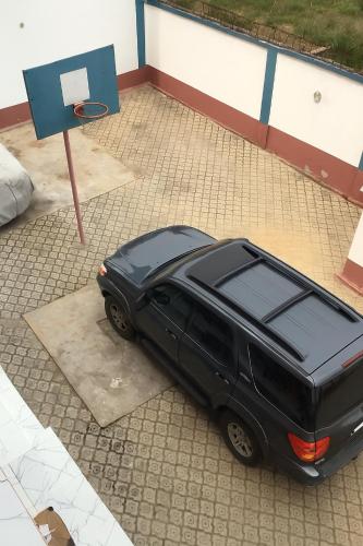 a black suv parked in a driveway with a basketball hoop at Hôtel Charles in Brazzaville