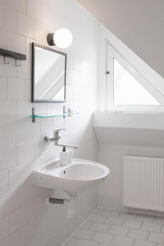 a white bathroom with a sink and a mirror at Horské Apartmány Smrčina in Janske Lazne