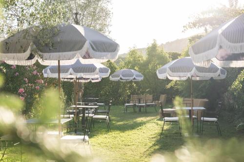 a group of tables and chairs with umbrellas at Boutique Guesthouse GIUS La Damaglück in Marciaga