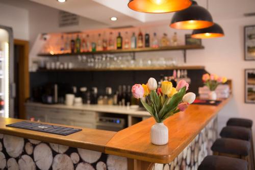 a bar with a vase of flowers on a counter at Horské Apartmány Smrčina in Janske Lazne