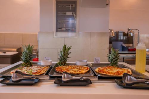 three pizzas on a counter in a kitchen at Smy Kos Beach & Splash in Mastichari