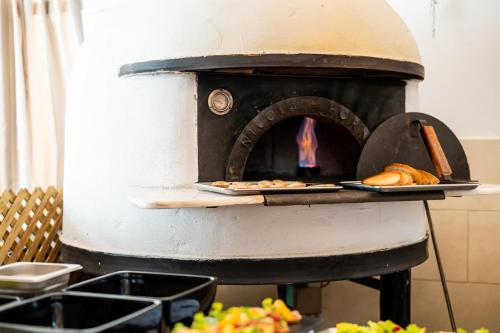 a pizza oven with bread and pastries on a tray at Smy Kos Beach & Splash in Mastichari