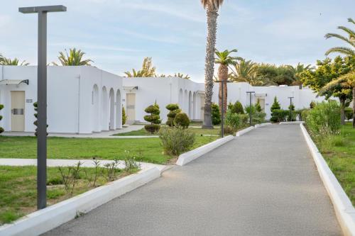 a walkway in front of a white building at Smy Kos Beach & Splash in Mastichari
