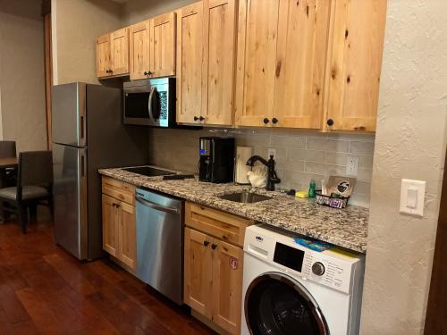 a kitchen with wooden cabinets and a washer and dryer at Stonewater Cove in Shell Knob