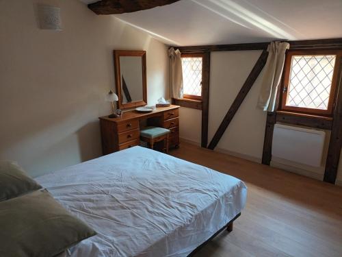 a bedroom with a bed and a dresser with a mirror at Gite medieval St Jacques in Parthenay