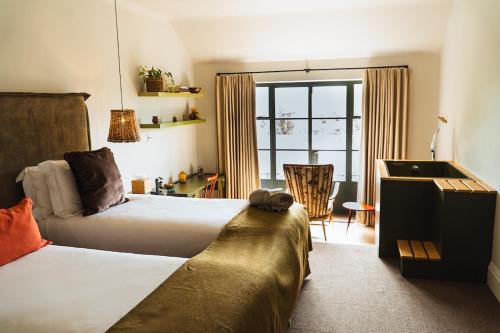 a hotel room with two beds and a couch at Combe Grove Health and Wellness in Bath