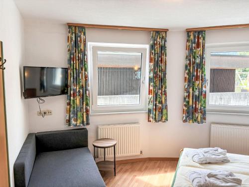 a bedroom with a couch and a tv and a window at Apartment Apart Edi by Interhome in Kappl