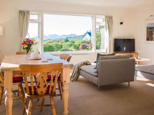 a living room with a table and a couch at Holiday Home Creag Dubh by Interhome in Camastianavaig