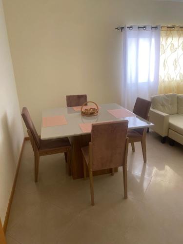 a dining room table with chairs and a couch at Apartamento T2 em Palmarejo in Prainha