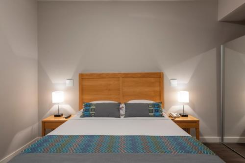 a bedroom with a large bed with two lamps at Monreale Express Glicério Campinas in Campinas