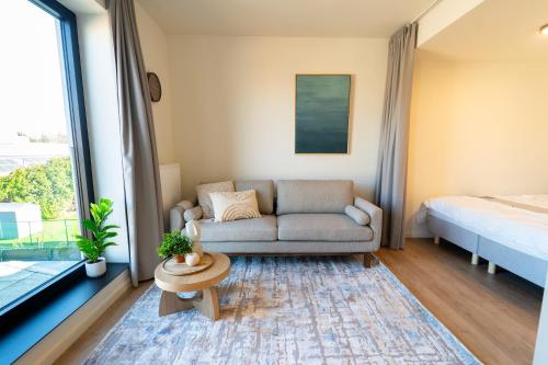a living room with a couch and a bed at Fourstay Luxury City Apartments Diegem - Brussels in Diegem