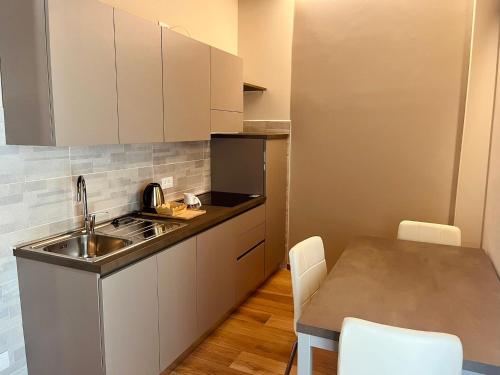 a kitchen with a sink and a table with chairs at Love story guest house in Cormòns